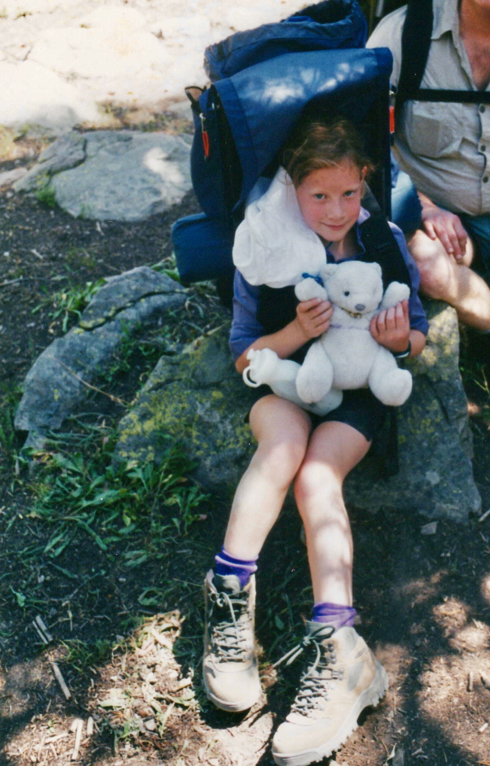 Kid backpacking, holding her stuffed animal