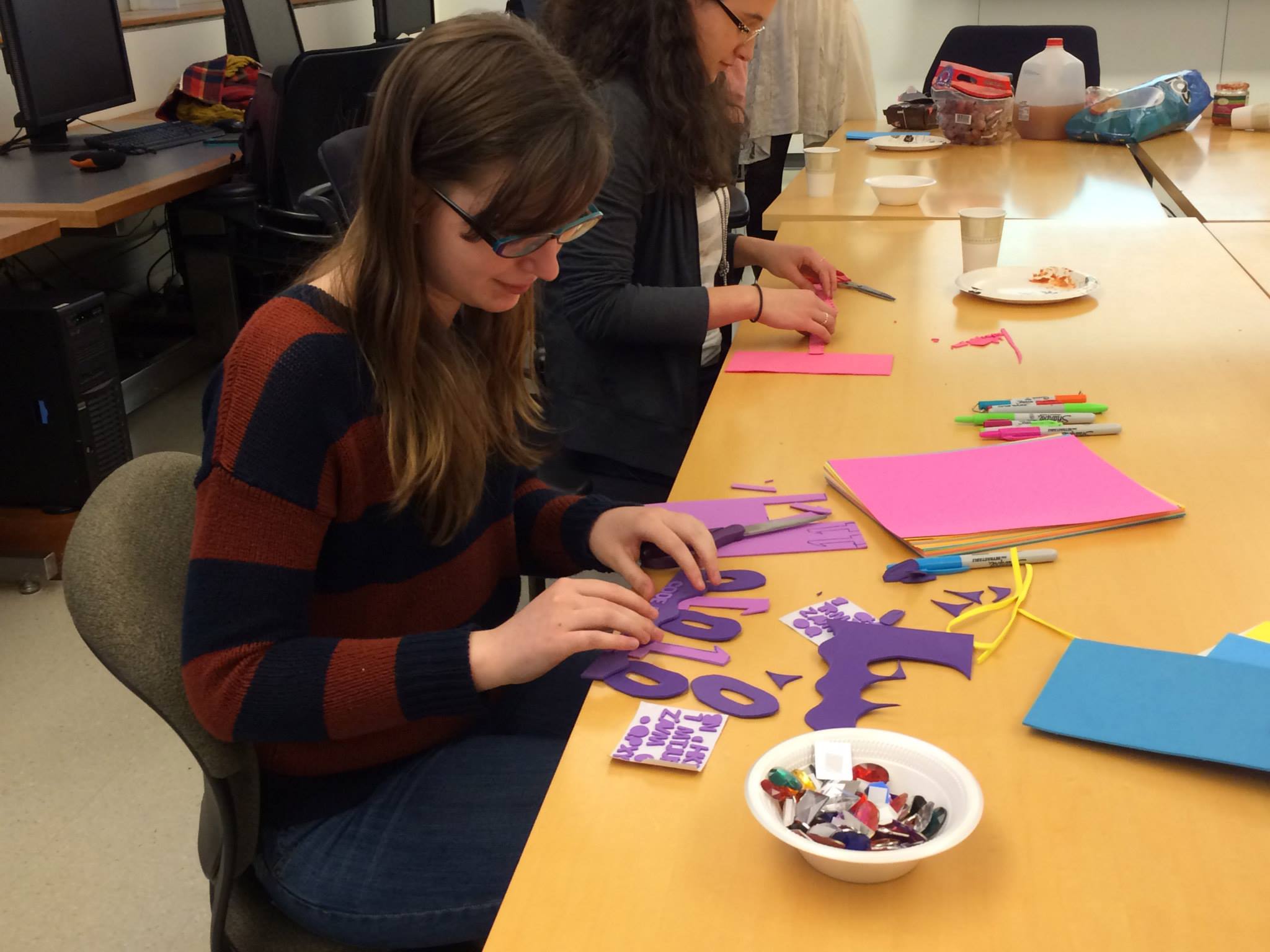 A sitting student with supplies spread out on the table in front of her.