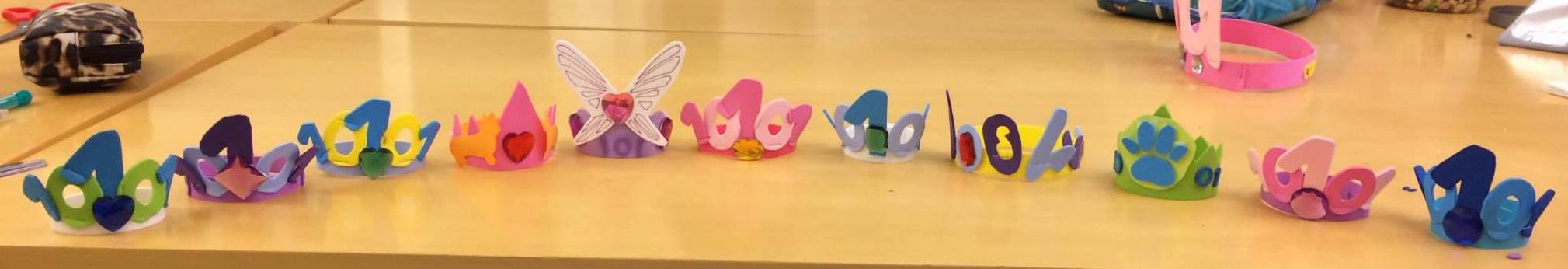 Ten foam crowns positioned in a semi-circle on a table.